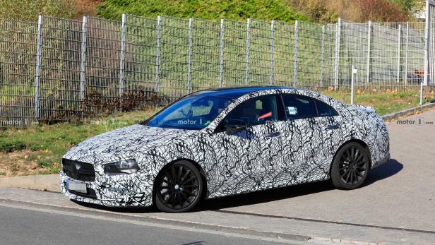 Ein Prototyp der Mercedes-Benz CLA-Klasse mit Tarnmuster auf einer Straße.