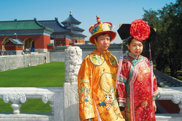 Zwei Personen in traditionellen chinesischen Kostümen vor dem Himmelstempel in Peking.