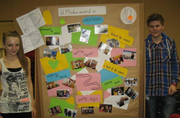 Zwei Jugendliche stehen vor einer Pinnwand zum Thema „34 Media around us“.
