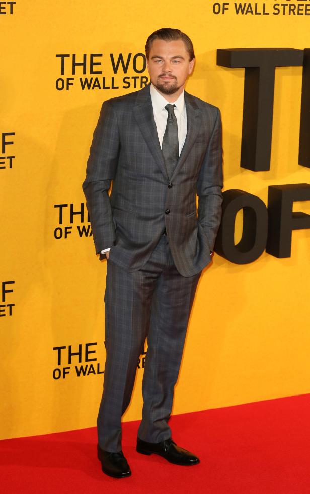 Leonardo DiCaprio auf dem roten Teppich vor einer Wand mit dem Titel „The Wolf of Wall Street“.