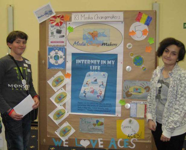 Zwei Jugendliche stehen vor einer Präsentation zum Thema „Media Changemakers“.