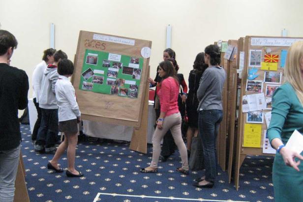 Eine Gruppe von Menschen betrachtet Präsentationen auf einer Veranstaltung.