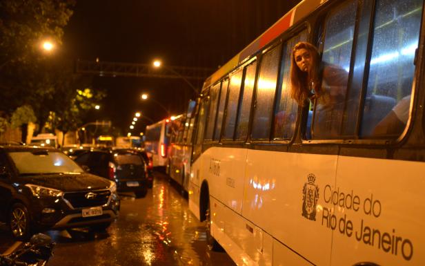 A woman looks out of the window of a bus in a traffic jam during heavy rains in the Jardim Botanico neighborhood in Rio de Janeiro