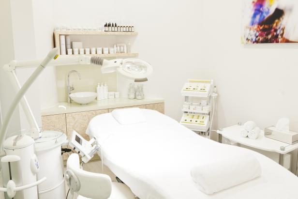 Ein Behandlungsraum in einem Kosmetikstudio mit Liege und Geräten.