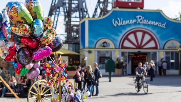 Ein Verkaufsstand mit bunten Ballons und Spielzeug vor dem Wiener Riesenrad.