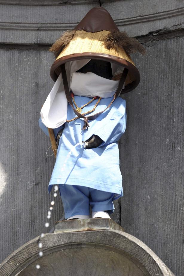 Die Statue Manneken Pis in Brüssel ist mit einem traditionellen vietnamesischen Hut und Gewand bekleidet.