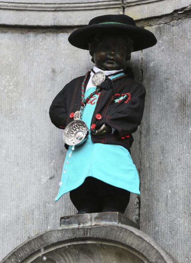 Die Statue des Manneken Pis in Brüssel, bekleidet mit einem Kostüm.