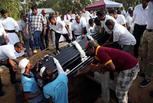 People lower the coffin of Sajuni, 23, who died during a string of suicide bomb attacks on churches and luxury hotels on Easter Sunday, at her funeral in Negombo
