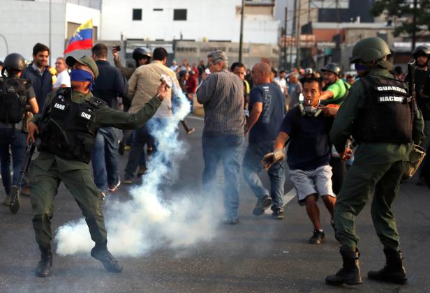 A military member throws a tear gas canister near the Generalisimo Francisco de Miranda Airbase in Caracas