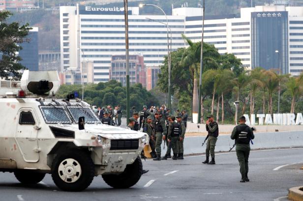 Military members stand guard near the Generalisimo Francisco de Miranda Airbase in Caracas