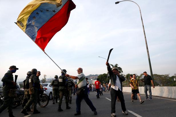 An opposition supporter waves a Venezuelan flag near the Generalisimo Francisco de Miranda Airbase in Caracas