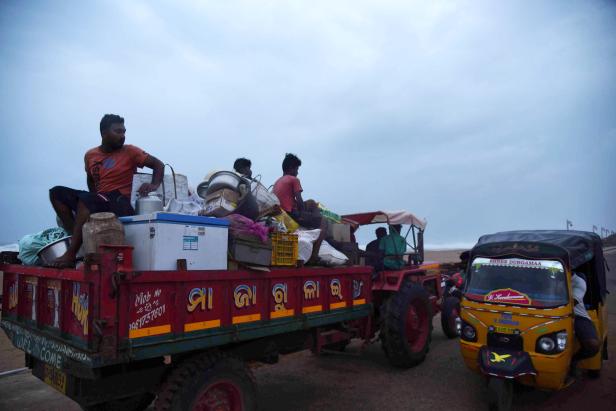 Villagers sit on a vehicle as they leave for a safer place ahead of cylcone Fani on the outskirts of Konark in the eastern state of Odisha