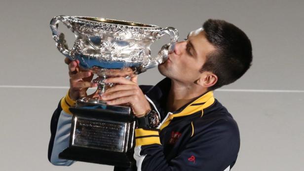 Novak Đoković küsst die Trophäe nach seinem Sieg.