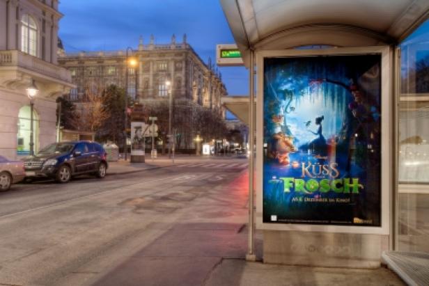 Ein Bushaltestellenschild wirbt für den Disney-Film „Küss den Frosch“.