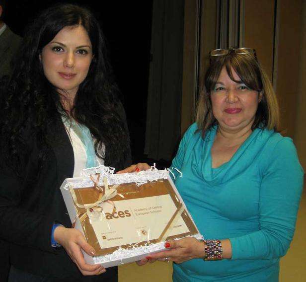 Zwei Frauen halten eine Auszeichnung der „Academy of Central European Schools“.