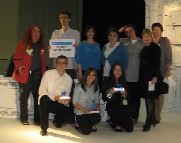 Eine Gruppe von Personen posiert mit Auszeichnungen und einem Schild mit der Aufschrift „Student Participation“.