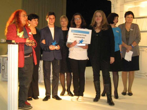 Eine Gruppe von Personen steht auf einer Bühne und hält Auszeichnungen für „Innovative Learning“.