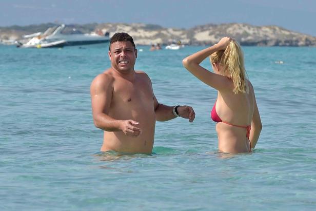 Ronaldo Nazário steht mit einer Frau im türkisfarbenen Wasser.