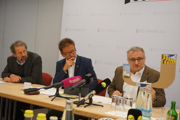 Drei Männer sitzen an einem Tisch bei einer Pressekonferenz zum Thema Atomkraft.