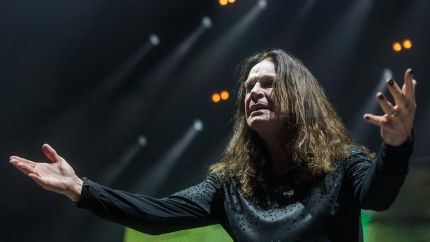 Ozzy Osbourne steht mit ausgestreckten Händen auf der Bühne.