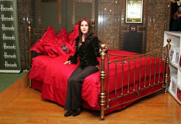Priscilla Presley sitzt auf einem roten Bett in einem Harrods-Kaufhaus.
