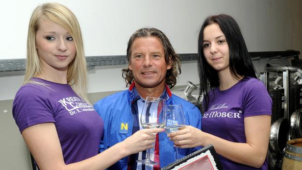 Ein Mann stößt mit zwei Frauen mit Weingläsern an.