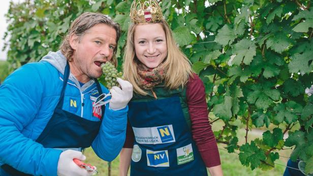 Ein Mann isst Weintrauben, während eine Frau mit Krone daneben steht.