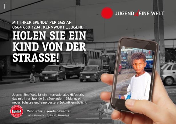 Ein Handy zeigt das Bild eines Jungen vor einem grauen Hintergrund mit Autos und Bussen.