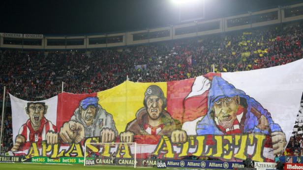 Ein großes Banner mit Comic-Figuren wird von Fußballfans im Stadion hochgehalten.
