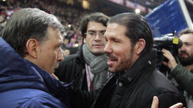 Diego Simeone im Gespräch mit einem anderen Mann am Spielfeldrand.