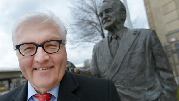 Frank-Walter Steinmeier posiert neben einer Statue.
