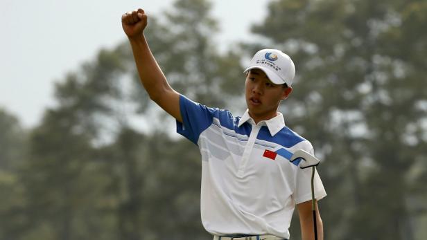 Ein junger Golfer mit chinesischer Flagge auf dem Hemd reckt jubelnd die Faust in die Luft.