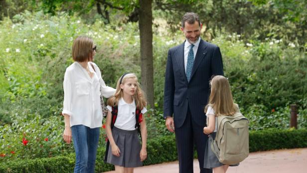 König Felipe und Königin Letizia mit ihren Töchtern Leonor und Sofía in einem Garten.