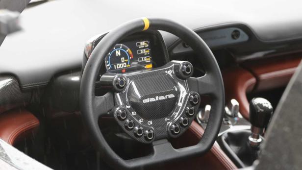 Das Lenkrad eines Dallara-Sportwagens mit digitalem Display und zahlreichen Bedienelementen.
