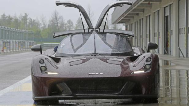 Ein dunkelroter Dallara Stradale mit geöffneten Flügeltüren im Regen.