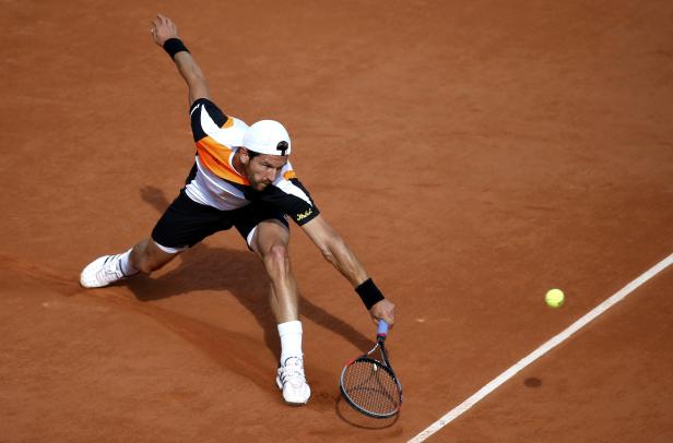 Jurgen Melzer of Austria plays a shot to Adrian Mannarino of France during their men's singles match at the French Open tennis tournament at the Roland Garros stadium in Paris