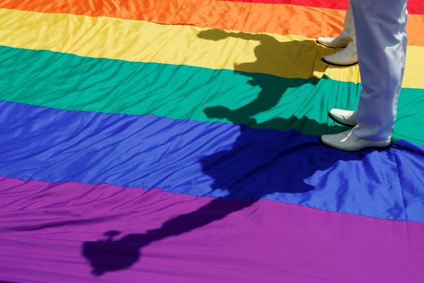 Gay newlyweds walk on a giant rainbow flag at a pro same-sex marriage party after registering their marriage in Taipei