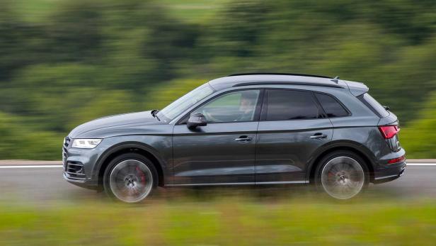 Ein grauer Audi SQ5 fährt auf einer Landstraße.