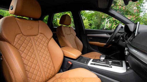 Das Interieur eines Autos mit braunen Ledersitzen im Rautenmuster.