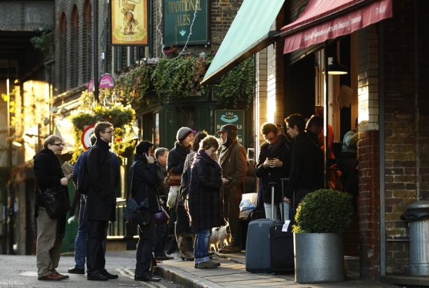 Eine Gruppe von Menschen steht vor einem traditionellen Pub in London.