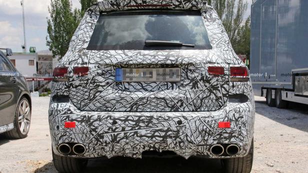 Die Rückansicht eines mit Tarnmuster beklebten Autos mit vier Auspuffrohren.