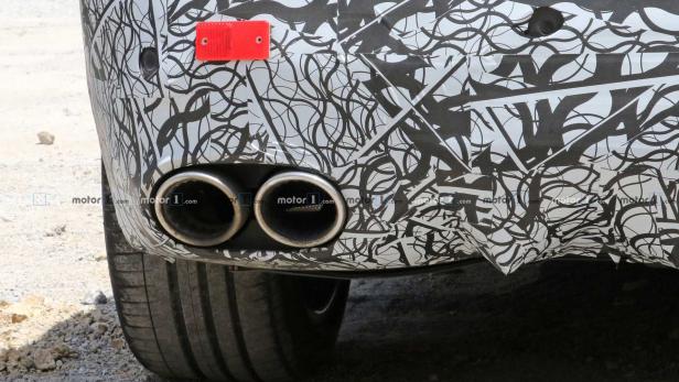 Detailansicht des Hecks eines mit Tarnfolie beklebten Autos mit zwei Auspuffrohren.