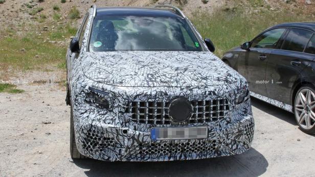 Ein Prototyp eines Mercedes-Benz GLC mit Tarnmuster steht im Freien.