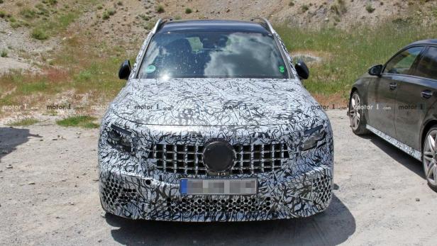 Ein Prototyp eines Mercedes-Benz-Autos mit einer Tarnfolie auf einer Schotterstraße.