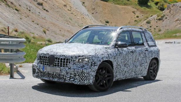 Ein mit Tarnfolie beklebter Mercedes-Benz SUV fährt auf einer Straße.