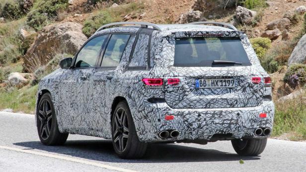 Ein mit Tarnmuster beklebter Mercedes-Benz SUV fährt auf einer Straße.
