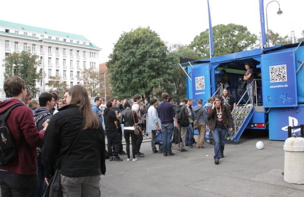 Eine Menschenmenge versammelt sich vor einem blauen PlayStation-Truck.