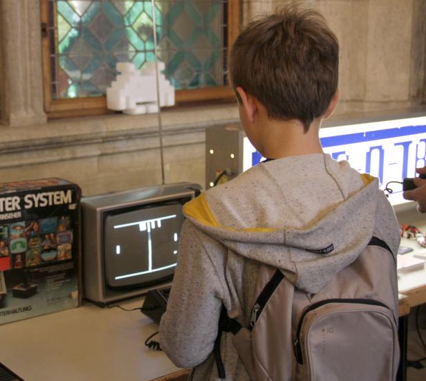 Ein Junge spielt ein Retro-Videospiel auf einem alten Röhrenfernseher.