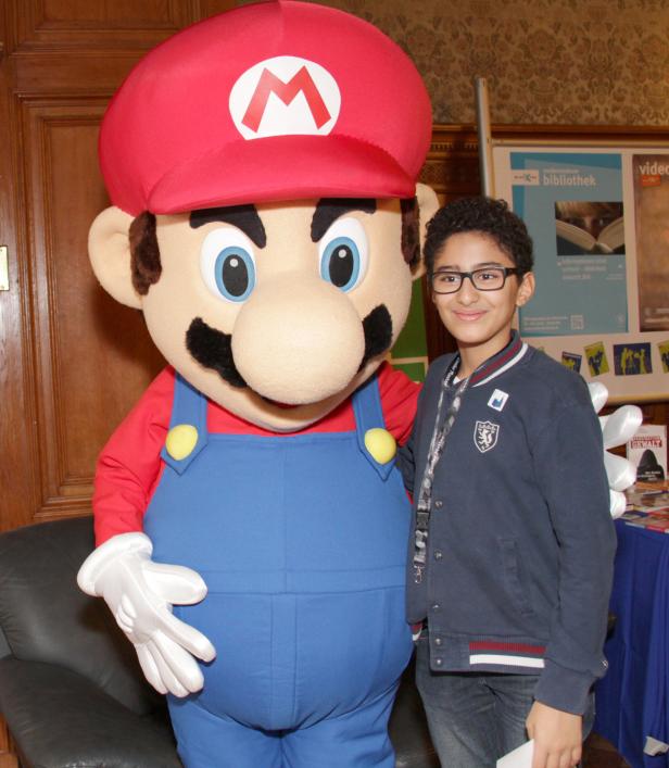Ein Junge posiert mit einem Mario-Kostüm für ein Foto.