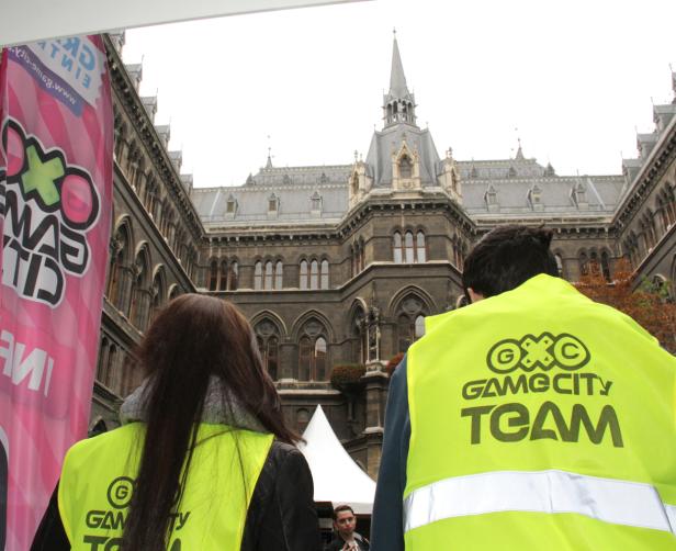 Zwei Personen mit „Game City“-Teamwesten vor dem Wiener Rathaus.